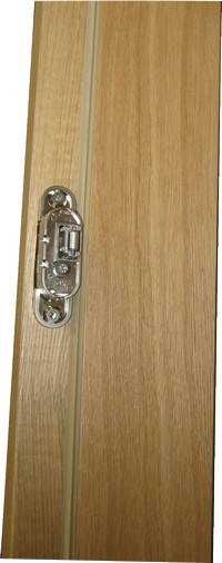 Detal bezprzylgowych drzwi drewnianych fornirowanych dębem z ukrytymi zawiasami, montowanych w Kośmidrach.